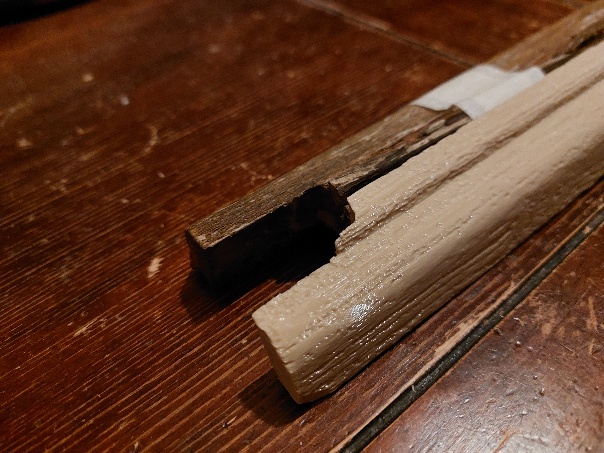 Détail rapproché de la jonction entre le bois d’origine abîmé et la moulure reproduite en impression 3D